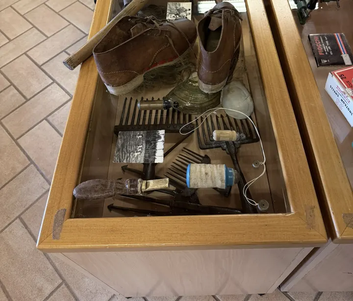 Una vetrina con scarpe da lavoro, rocchetti e attrezzi da caccia