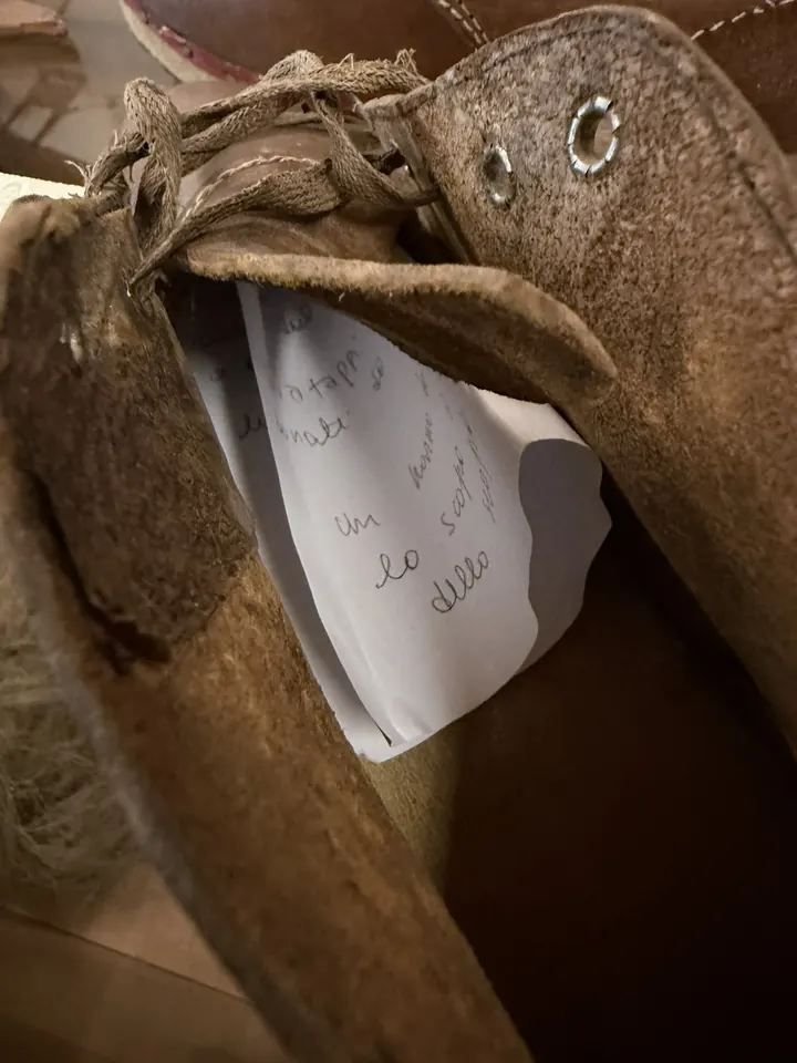 Un biglietto scritto a mano infilato in una vecchia scarpa di cuoio