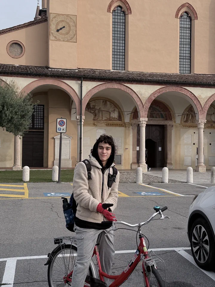 Un compagno con la bicicletta davanti al portico ad archi del santuario delle Grazie