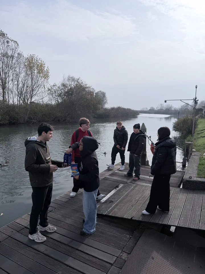 Compagni di classe sul pontile di legno davanti al museo, con il Mincio e le sponde alberate alle spalle